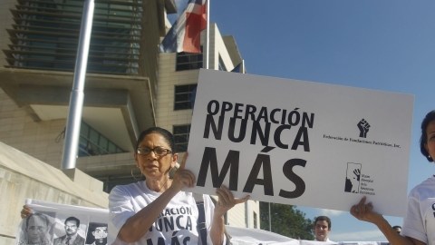 Varias personas marchan hacia la Procuraduría de la República  portando unos lienzos con los rostros de algunas víctimas del régimen de Rafael Leónidas Trujillo (1930-1961).
