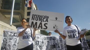 Varias personas marchan hacia la Procuraduría de la República  portando unos lienzos con los rostros de algunas víctimas del régimen de Rafael Leónidas Trujillo (1930-1961).