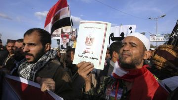 Un egipcio sujeta un ejemplar de la Constitución egipcia durante una manifestación en defensa del presidente Mohamed Morsi convocada en el distrito de Nasr, El Cairo.