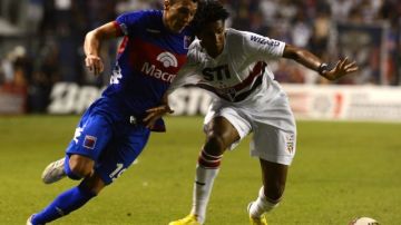 El jugador de Tigre Rubén Botta (izq.) lucha por el balón con Bruno Cortez del Sao Pablo el pasado miércoles 5 de diciembre, en el primer partido de la final de la copa Sudamericana.