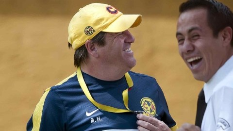Miguel Herrera bromea con un miembro de seguridad del Club América antes de que el equipo emprendiera el viaje ayer a Avándaro.