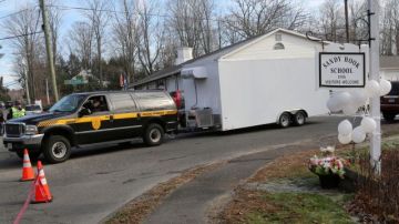 La camioneta del examinador médico de Newton abandona la escuela primaria   Sandy Hook.