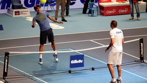 El tenista Roger Federer (izq) devuelve la pelota al arquero colombiano Farid Mondragón durante una exhibición en Bogotá.