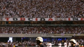 Oficiales de policía abandonan el campo de juego mientras los jugadores del Sao Paulo esperaban el regreso de los integrantes de Tigre, que perdía 2-0 al final del primer tiempo de la final de la Copa Sudamericana.
