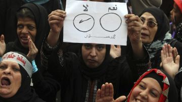 Una mujer sostiene un cartel en el que se lee, en árabe, 'No a la Constitución' durante una manifestación contra el gobierno.