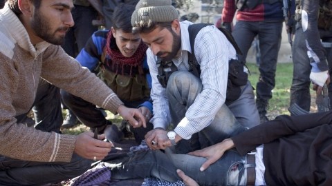 Miembros del Ejército de Liberación Sirio ayudan a un camarada herido por un francotirador en Aleppo, donde las fuerzas rebeldes tienen su fortín.