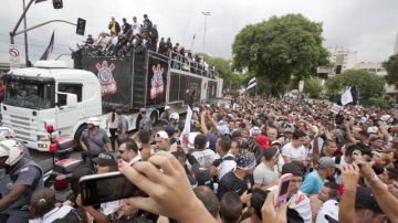 Jugadores del Corinthians saludan a un centenar de hinchas  desde un camión  en una calle de Sao Paulo donde fueron aclamados.