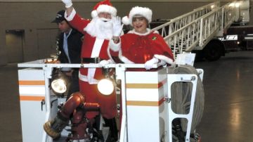 Foto de archivo del 18 de diciembre 2004 en la que aparece Santa Claus y la señora Claus saludando a los niños desde un camión.