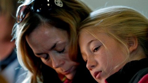 Molly Delaney (izq.) sostiene a su hija,  de 11 años, Milly Delaney, durante un servicio en honor de las víctimas de Newtown.