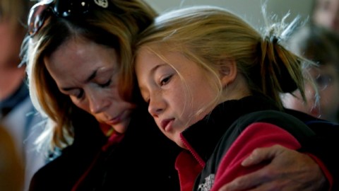 Molly Delaney (izq.) sostiene a su hija, de 11 años, Milly Delaney, durante un servicio en honor de las víctimas de Newtown.