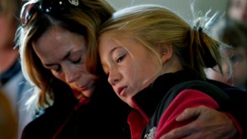 Molly Delaney (izq.) sostiene a su hija,  de 11 años, Milly Delaney, durante un servicio en honor de las víctimas de Newtown.