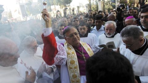 El patriarca latino de Jerusalén, Fuad Twal (c), bendice a los feligreses de camino a la iglesia de la Natividad en Belén, Cisjordania.