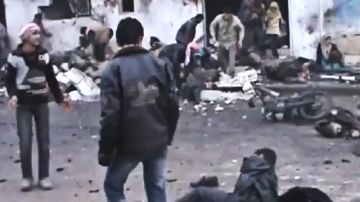 Imagen tomada de un video que muestra a sirios removiendo los cuerpos dentro de una panadería,  que fue  bombardeada.