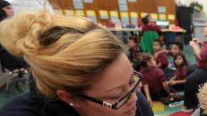 La madre de una alumna y voluntaria Alma Valdez (i) ayuda a los estudiantes de 3er grado durante una clase en la Escuela charter Futuro.