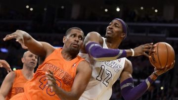 El jugador de los Lakers Dwight Howard (12) recibe una falta de Kurt Thomas (48) de los Knicks durante el partido en Los Ángeles.