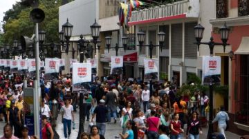 Ciudadanos caminan por las calles adornadas con mensajes alusivos al presidente Hugo Chávez  en el centro de Caracas.