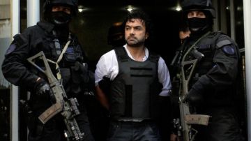 Agentes antinarcóticos escoltan al colombiano, Henry de Jesús López Londoño, detenido en  las afueras de Buenos Aires el 31 de octubre pasado.