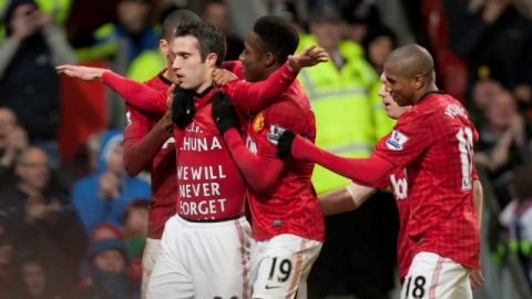 Robin van Persie (20) es felicitado por sus compañeros tras anotar y dar el triunfo ayer a los 'red devils'.