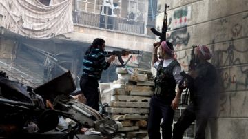 Miembros del Ejército de Liberación sirio disparan a posiciones enemigas durante  enfrentamientos  con las fuerzas del gobierno en en el distrito de Salaheddine.