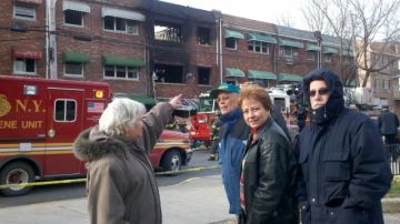 Josephine Linares señala el edificio  de El Bronx donde ayer un incendio cobró tres vidas. Linares en la foto junto a  su esposo  José, Carmen Cardona y el esposo de ésta, David Reich vive en el inmueble adyacente al siniestrado.