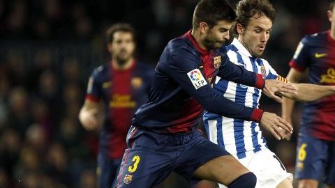 El defensa del FC Barcelona Gerard Piqué disputa el balón con el centrocampista del Espanyol Joan Verdú.