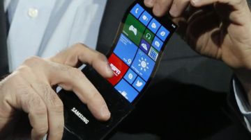 Eric Rudder, jefe de estrategia técnica de Microsoft, sostiene un prototipo de smartphone con pantalla OLED durante la presentación de Samsung en CES.