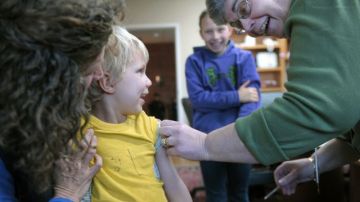La enfermera Kris Magnussen vacuna a Alexander Dyjak, de 4 años, en Ledge Light Health District en New London, Connecticut.