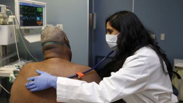 La doctora Meeta Khan utiliza una mascarilla protectora al revisar pacientes que pudieran estar sufriendo por el virus de la influenza.