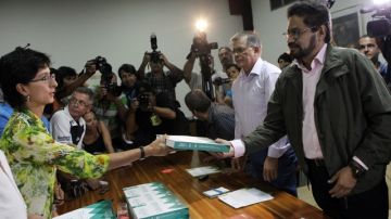 Olga Rodríguez (i), funcionaria de la ONU, entrega a Luciano Marín Arango, de las FARC, las 546 propuestas recogidas en un foro agrario  en diciembre pasado.
