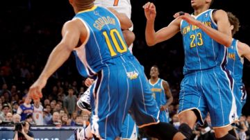 Carmelo Anthony se eleva para disparar al aro, ante la marca de Eric Gordon y Anthony Davis de los Hornets, en un partido en el que marcó 27 puntos y llevó a los Knicks a la victoria.