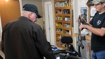 El vendedor de una tienda en Texas muestra a un cliente diferentes rifles de asalto, mientras se debate un mayor control.