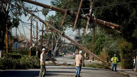 FILE - This Dec. 2, 2011 file photo shows crews from Southern California Edison power company working to clean up and restore power on Live Oak Avenue, in Temple City, Calif. A report by the California Public Utilities Commission faulted Southern California Edison for its response during the 2011 windstorm that left some 440,000 customers in the dark. (AP Photo/Bret Hartman, File)