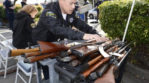Un oficial revisa los rifles entregados durante un programa de intercambio de armas, al tiempo en que crece el apoyo a un mayor control.