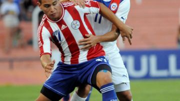 Franco Ragusa (der.) de Chile, trata de robar el balón al paraguayo   Jorge Balbuena en el primer tiempo del partido celebrado ayer.