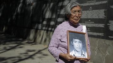 Cunegunda Peña, de 76 años, sostiene un retrato de su hijo desaparecido  en el Monumento a la Memoria y la Verdad en San Salvador.