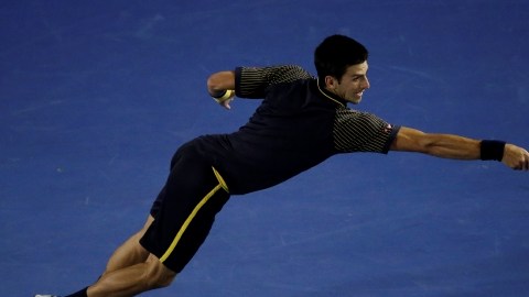 Novak Djokovic  se esfuerza al máximo para devolverle una bola a Ryan Harrison, quien cayó derrotado en tres sets corridos.