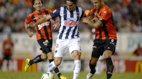 Aldo de Nigris (centro) y Miguel Martínez (der.) pelean por el balón en duelo de la fecha 3.