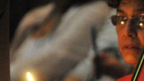 Una mujer, sentada cerca a una fotografía del presidente de Venezuela, Hugo Chávez, asiste a una misa en la catedral de La Habana (Cuba) por la salud del gobernante.