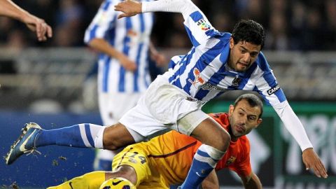 Carlos Vela pelea un balón con el defensa argentino del FC Barcelona, Javier Mascherano, en partido de la jornada 20 de Liga Española.