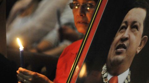 Una mujer, sentada cerca a una fotografía del presidente de Venezuela, Hugo Chávez, asiste a una misa en la catedral de La Habana, el pasado 12 de enero de 2013.