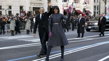 El presidente de EEUU, Barack Obama, y su mujer saludan en su desfile de investidura, en Washington.