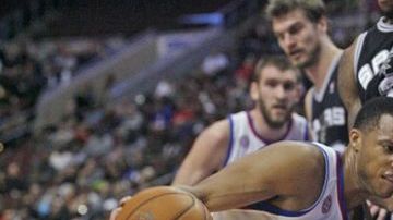 Kawhi Leonard de Spurs defiende el balón ante  Evan Turner (12) de los 76ers de Filadelfia .