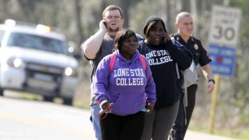 Estudiantes caminan por el campus mientras la policía recolecta evidencia del tiroteo.