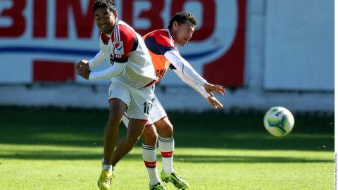 Miguel Sabah, atrás, pelea el balón con Fabián de la Mora en la práctica de las Chivas con miras a su duelo del viernes en Morelia.