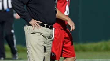 El entrenador de los 49ers, Jim Harbaugh (i), en una práctica junto a su mariscal de campo Alex Smith.