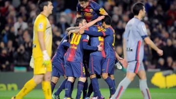 Jugadores del Barsa hacen 'bolita' a Lionel Messi  (10) para felicitarlo luego de que anotara su cuarto gol al Osasuna ayer en el Camp Nou.
