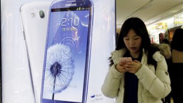 Una mujer junto a un anuncio publicitario de Samsung Electronics en Seúl.