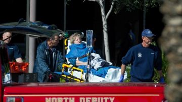 A woman is taken to a paramedic truck from an office building where a shooter opened fire in north central Phoenix on Wednesday, Jan. 30, 2013. (AP Photo/The Arizona Republic, Michael Schennum)