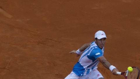 El tenista argentino Juan Mónaco devuelve al bola a Florian Mayer