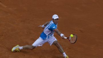El tenista argentino Juan Mónaco devuelve al bola a Florian Mayer